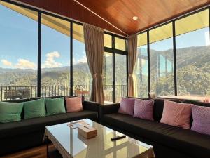 a living room with a couch and large windows at 自在居森林民宿 in Wufeng