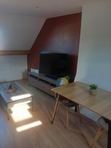 a living room with a table and a tv at Cote d'opale Terre & Mer in Outreau