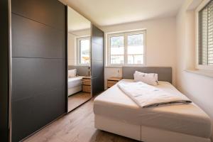 a small bedroom with a bed and a mirror at Appartement Bergblick Eben in Eben im Pongau