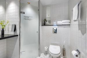 a bathroom with a toilet and a glass shower at Hotel Hedegaarden in Vejle +32 photos