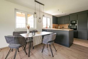 a kitchen with a dining room table and chairs at Appartement Bergblick Eben in Eben im Pongau