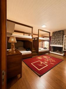 a room with bunk beds and a red rug at Lake House Mantasoa in Mantasoa