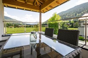 a glass table and chairs on a balcony with a view at Appartement Bergblick Eben in Eben im Pongau