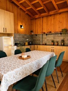 a kitchen with a table with green chairs and a kitchen at Lake House Mantasoa in Mantasoa