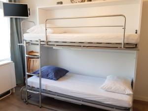 two bunk beds in a room with a tv at Studio cosy avec balcon et vue sur la montagne à Chamrousse - 19 m² in Chamrousse