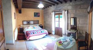 a bedroom with a bed and a table at Antigua Posada, Valle del Jerte in Tornavacas