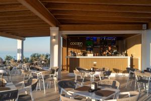 ein Restaurant mit Tischen und Stühlen und einer Bar in der Unterkunft AMASEA Resort in San Teodoro