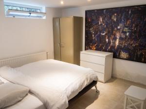 a bedroom with a bed and a painting on the wall at Comfortable Apartment in Waterloo with Jacuzzi - 78m² in Waterloo