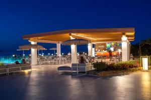 ein Restaurant mit Tischen und Sonnenschirmen bei Nacht in der Unterkunft AMASEA Resort in San Teodoro