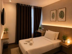 a hotel room with a bed and a window at Point Stay GH in Kuching