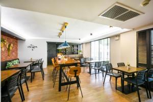 a dining room with wooden tables and chairs at Kitzio House Hotel Huai Kwang in Bangkok