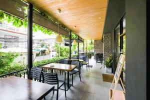 a restaurant with tables and chairs on a patio at Kitzio House Hotel Huai Kwang in Bangkok