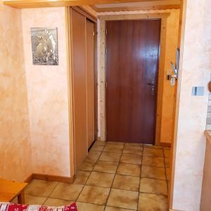 a hallway with a wooden door and a tile floor at Studio cosy à Les Gets 25 m² avec vue montagne in Les Gets