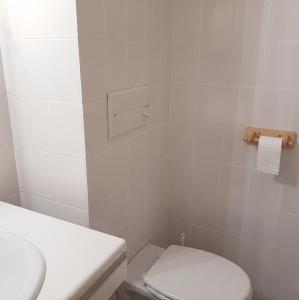 a white bathroom with a toilet and a sink at Studio cosy à Les Gets 25 m² avec vue montagne in Les Gets +3 photos