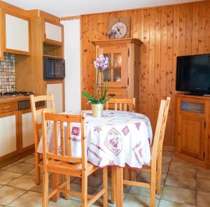 a kitchen with a table with chairs and a tv at Studio cosy à Les Gets 25 m² avec vue montagne in Les Gets