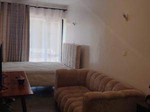 a living room with a couch and a bed at A006 Ss2 in Kiambu
