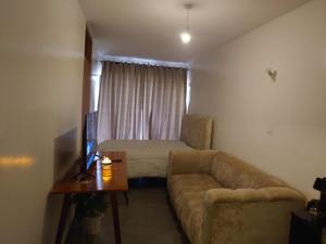 a living room with a couch and a bed at A006 Ss2 in Kiambu
