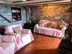 a living room with two beds and two chairs at Sea-view house in Fajã da Ovelha with garden and terrace in Fajã da Ovelha