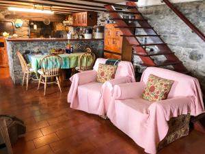 a dining room with pink chairs and a table at Sea-view house in Fajã da Ovelha with garden and terrace in Fajã da Ovelha +37 photos