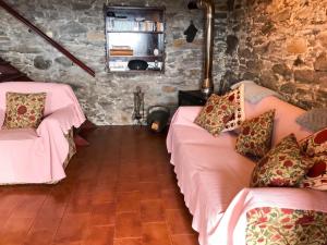 two beds in a room with stone walls at Sea-view house in Fajã da Ovelha with garden and terrace in Fajã da Ovelha