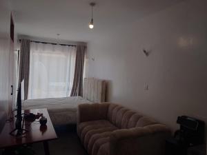a living room with a couch and a bed at A006 Ss2 in Kiambu