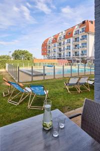 a table with two chairs and a bottle of wine on it at Holiday Suites Zeebrugge in Zeebrugge