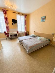 a bedroom with a bed and a table and chairs at Charmant studio à Néris-les-Bains 20 m² avec jardin privé in Néris-les-Bains