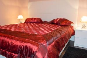 a bedroom with a large red bed with two lamps at Appartement spacieux Gérardmer 90 m² in Gérardmer