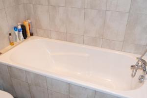 a bath tub with a faucet in a bathroom at Appartement spacieux Gérardmer 90 m² in Gérardmer