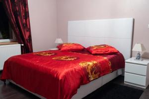 a bed with a red blanket and two pillows at Appartement spacieux Gérardmer 90 m² in Gérardmer