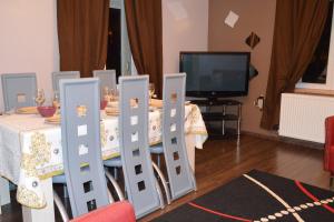 a dining room with a table with chairs and a television at Appartement spacieux Gérardmer 90 m² in Gérardmer +24 photos