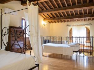 a bedroom with two beds and a balcony at Charming house in Ramazzano - Le Pulci with shared pool in Ramazzano