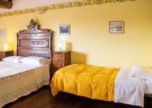 a bedroom with two beds with yellow walls at Charming house in Ramazzano - Le Pulci with shared pool in Ramazzano