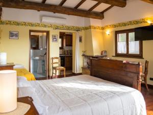 a bedroom with a large bed and a kitchen at Charming house in Ramazzano - Le Pulci with shared pool in Ramazzano