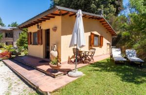a house with an umbrella and a table and chairs at Charming house in Ramazzano - Le Pulci with shared pool in Ramazzano +31 photos