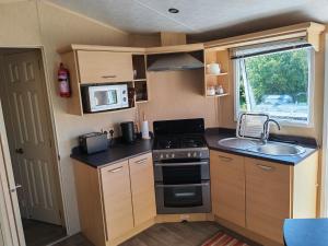 a kitchen with a stove and a sink in a caravan at Winnie the Mobile Home in Galway