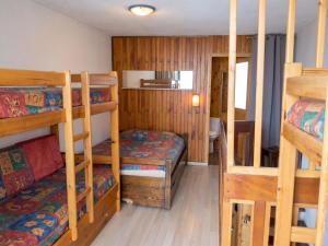 a room with three bunk beds and a staircase at Appartement charmant à Les Menuires, 36 m², vue montagne. in Saint-Martin-de-Belleville