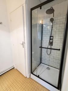 a shower with a glass door in a bathroom at Charmant studio à Néris-les-Bains de 20 m² in Néris-les-Bains