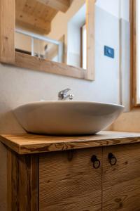 a bathroom sink sitting on top of a wooden counter at Agriturismo Piccola Baita in Falcade