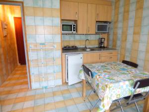a small kitchen with a table and a sink at Studio charmant dans Brioude – 25 m² avec terrasse et parking in Brioude