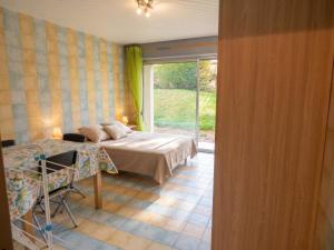 a bedroom with a bed and a table and a window at Studio charmant dans Brioude – 25 m² avec terrasse et parking in Brioude