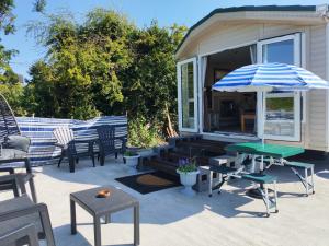 a patio with chairs and a table and an umbrella at Winnie the Mobile Home in Galway +3 photos