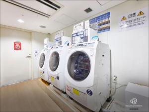 three washing machines are lined up in a room at Daiwa Roynet Hotel Tsukuba in Tsukuba