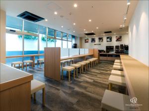 a restaurant with a bar with chairs and tables at Daiwa Roynet Hotel Tsukuba in Tsukuba