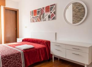 a bedroom with a bed and a dresser and a mirror at Welcoming Apartment in A Coruña, 90 m², Balcony in Serres