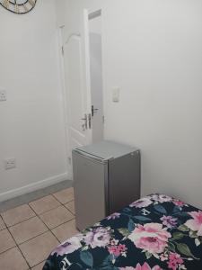 a room with a bed and a small refrigerator at LRN Brackenfell Homestay in Cape Town