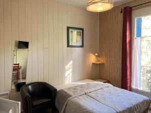 a bedroom with a bed and a chair and a window at Studio moderne à Néris-les-Bains de 17 m² in Néris-les-Bains