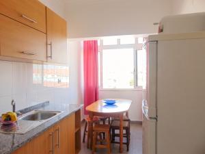 a kitchen with a sink and a table and a window at Comfortable Apartment in Feijó with Shared Pool, 90 m² in Almada