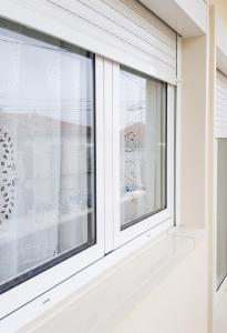 a window with white blinds on a house at Comfortable Apartment in Feijó with Shared Pool, 90 m² in Almada