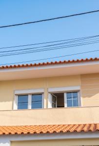 a house with two windows and a roof at Comfortable Apartment in Feijó with Shared Pool, 90 m² in Almada +21 photos